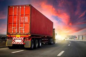 image motion blur.Truck on highway road with red container, transportation concept.,import,export logistic industrial Transporting Land transport on the asphalt expressway with sunrise sky. photo