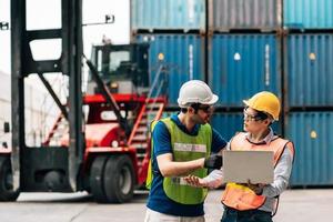 Team Engineer and worker wear safety uniform check control loading freight cargo container use computer laptop at commercial dock warehouse,transportation import,export logistic industrial service photo