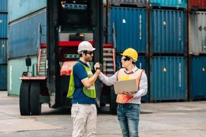 Team Engineer and worker wear safety uniform check control loading freight cargo container use computer laptop at commercial dock warehouse,transportation import,export logistic industrial service photo