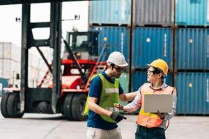 Team Engineer and worker wear safety uniform check control loading freight cargo container use computer laptop at commercial dock warehouse,transportation import,export logistic industrial service photo