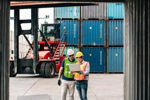Team Engineer and worker wear safety uniform check control loading freight cargo container use computer laptop at commercial dock warehouse,transportation import,export logistic industrial service photo