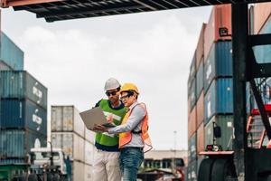 Team Engineer and worker wear safety uniform check control loading freight cargo container use computer laptop at commercial dock warehouse,transportation import,export logistic industrial service photo