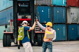 Team Engineer and worker wear safety uniform check control loading freight cargo container use computer laptop at commercial dock warehouse,transportation import,export logistic industrial service photo