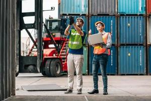 Team Engineer and worker wear safety uniform check control loading freight cargo container use computer laptop at commercial dock warehouse,transportation import,export logistic industrial service photo