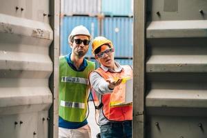 Team Engineer and worker wear safety uniform check control loading freight cargo container use computer laptop at commercial dock warehouse,transportation import,export logistic industrial service photo