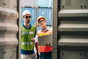 Team Engineer and worker wear safety uniform check control loading freight cargo container use computer laptop at commercial dock warehouse,transportation import,export logistic industrial service photo
