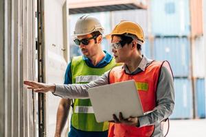 Team Engineer and worker wear safety uniform check control loading freight cargo container use computer laptop at commercial dock warehouse,transportation import,export logistic industrial service photo