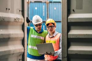 Team Engineer and worker wear safety uniform check control loading freight cargo container use computer laptop at commercial dock warehouse,transportation import,export logistic industrial service photo