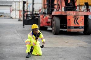 trabajador hombre en protector la seguridad mono uniforme con amarillo casco de seguridad y utilizar walkie película sonora cheque envase a carga Envío depósito. transporte importación y exportación logístico industrial Servicio foto