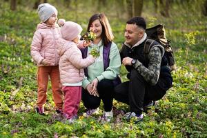 Family with two daughters on sunny forest. Outdoor spring leisure concept. photo