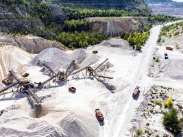 Aerial view of open cast limestone quarry with conveyor system and dump trucks. photo