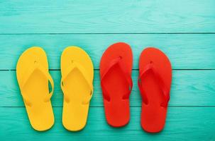 Colorful flip flops on blue wooden background with copy space. Top view photo