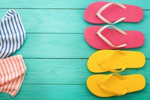 Pink flip flops with towels on blue wooden floor. Top view. Summer time. Copy space and mock up. Beach holidays photo