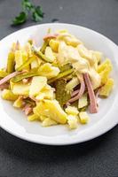 fresh potato salad, gherkin, sausage, mayonnaise ready to eat meal food snack on the table copy space food background rustic top view photo