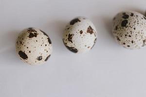little quail eggs on a light smooth background in close-up photo