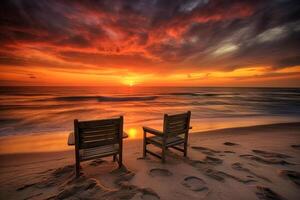 A colorful sunset on a Caribbean beach with clouds, two beach chairs on the beach. photo