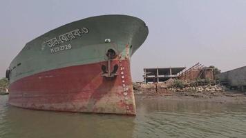 Side view of a big cargo ship from a moving water vessel. Big tanker ship footage on a riverbank. Industrial cargo ship side view on a riverbank. Water vessel, Dhaka, Bangladesh - April 16, 2023 video