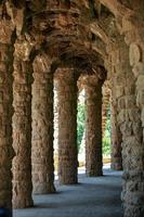 ancient arched gallery perspective, columns and vaults are made of rough, untreated stone photo