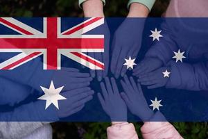 Hands of kids on background of Australia flag. Australian patriotism and unity concept. photo