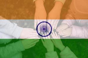 Hands of kids on background of India flag. Indian patriotism and unity concept. photo