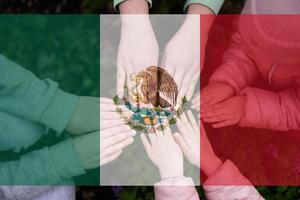 Hands of kids on background of Mexico flag. Mexican patriotism and unity concept. photo