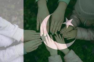 Hands of kids on background of Pakistan flag. Pakistani patriotism and unity concept. photo