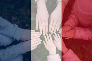 Hands of kids on background of France flag. French patriotism and unity concept. photo