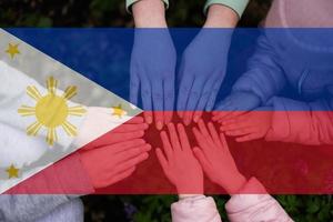 Hands of kids on background of Philippines flag. Filipino patriotism and unity concept. photo