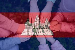 Hands of kids on background of Cambodia flag. Cambodian patriotism and unity concept. photo