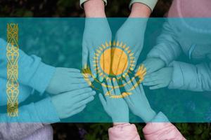 Hands of kids on background of Kazakhstan flag. Kazakhstani patriotism and unity concept. photo