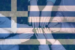 manos de niños en antecedentes de Grecia bandera. griego patriotismo y unidad concepto. foto