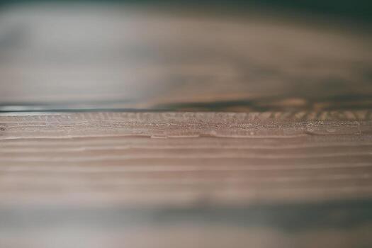 A close up of a wooden table with a water droplet on it photo