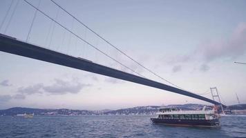 de brug en de stad in Istanbul. de veerboot passeert onder de brug in Istanbul. algemeen stad en Bosporus visie. video