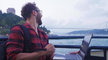 The man who is happy with his success on the laptop. Man working on laptop on ferry. Celebrating his success. video