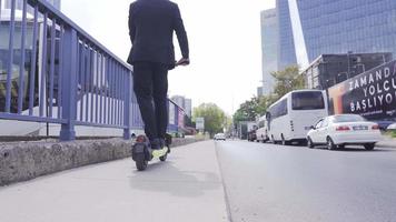 piernas de un hombre montando un eléctrico ecológico scooter. piernas de un hombre conducción un eléctrico ecológico scooter. un hombre soportes y paseos en un eléctrico scooter plataforma. video