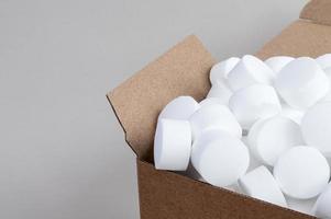 Part of an open box with pressed dishwasher salt top view photo