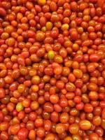 Tomatoes lying on a pile on top of each other, tomato texture. Selective focus. photo