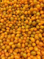 Small Tomatoes lying on a pile on top of each other, tomato texture. Selective focus. photo