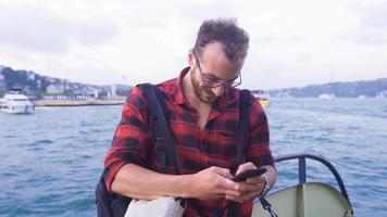 The man using the phone on the ferry. Man using phone on ferry driving in sea cityscape. Happy. video