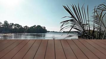 empty Wooden table top on the background of the river and palm leaves. focus nature green, abstract nature background with green leves. photo