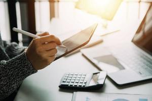 Financial analysts analyze business financial reports on a digital tablet planning investment project during a discussion at a meeting of corporate showing the results of their successful teamwork. photo