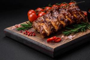 Delicious grilled pork ribs with sauce, spices and herbs photo