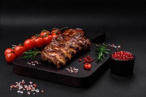 Delicious grilled pork ribs with sauce, spices and herbs photo