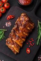 delicioso A la parrilla Cerdo costillas con salsa, especias y hierbas foto