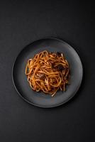 delicioso tallarines o udon con hongos, sal, especias y hierbas foto