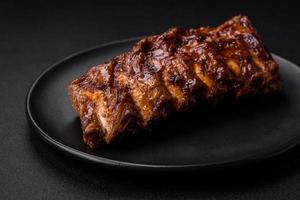 delicioso A la parrilla Cerdo costillas con salsa, especias y hierbas foto