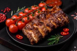 delicioso A la parrilla Cerdo costillas con salsa, especias y hierbas foto