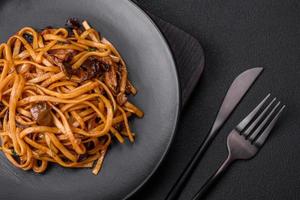 delicioso tallarines o udon con hongos, sal, especias y hierbas foto