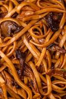 delicioso tallarines o udon con hongos, sal, especias y hierbas foto
