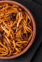 delicioso tallarines o udon con hongos, sal, especias y hierbas foto